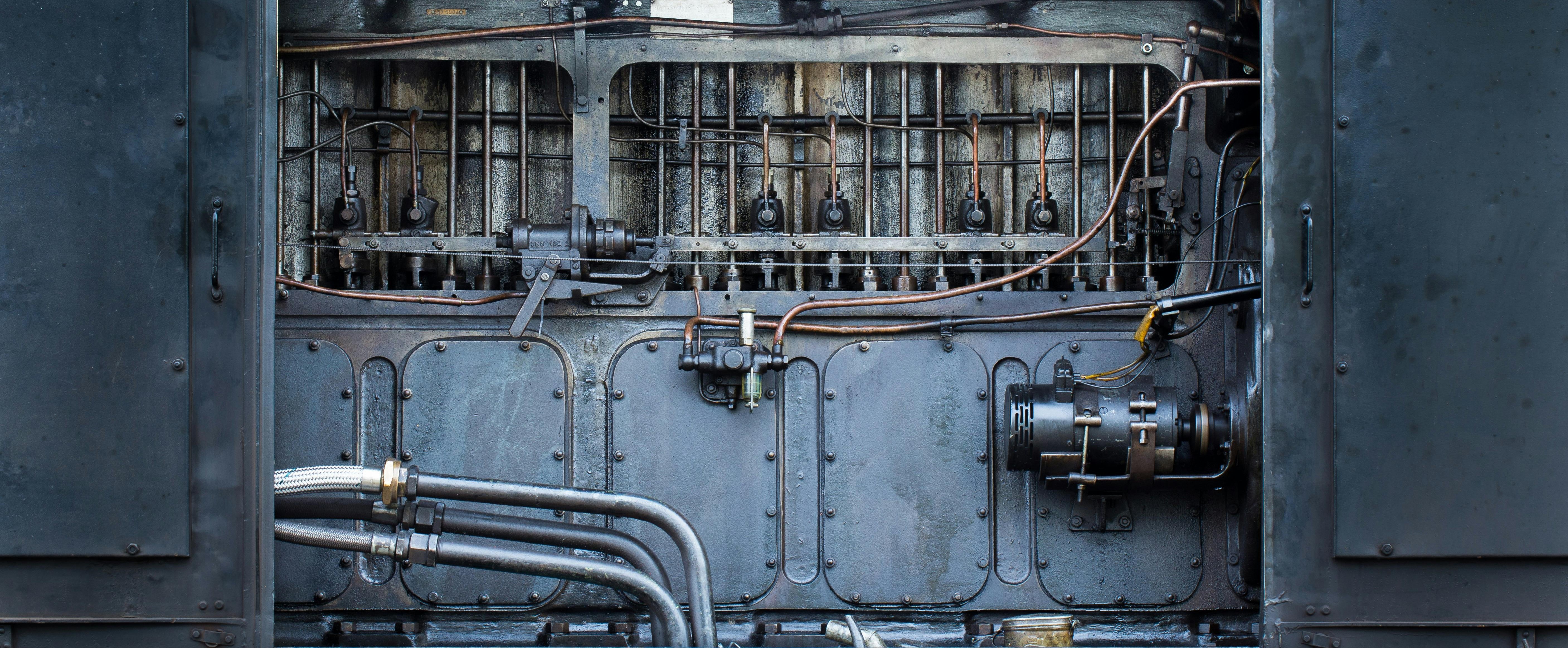 A picture of pipes and wires on a gray machine